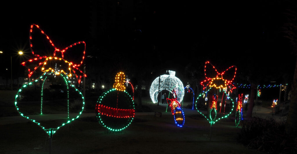 Oversized red, green and white ornament light sculptures on the lawn along the Boardwalk.